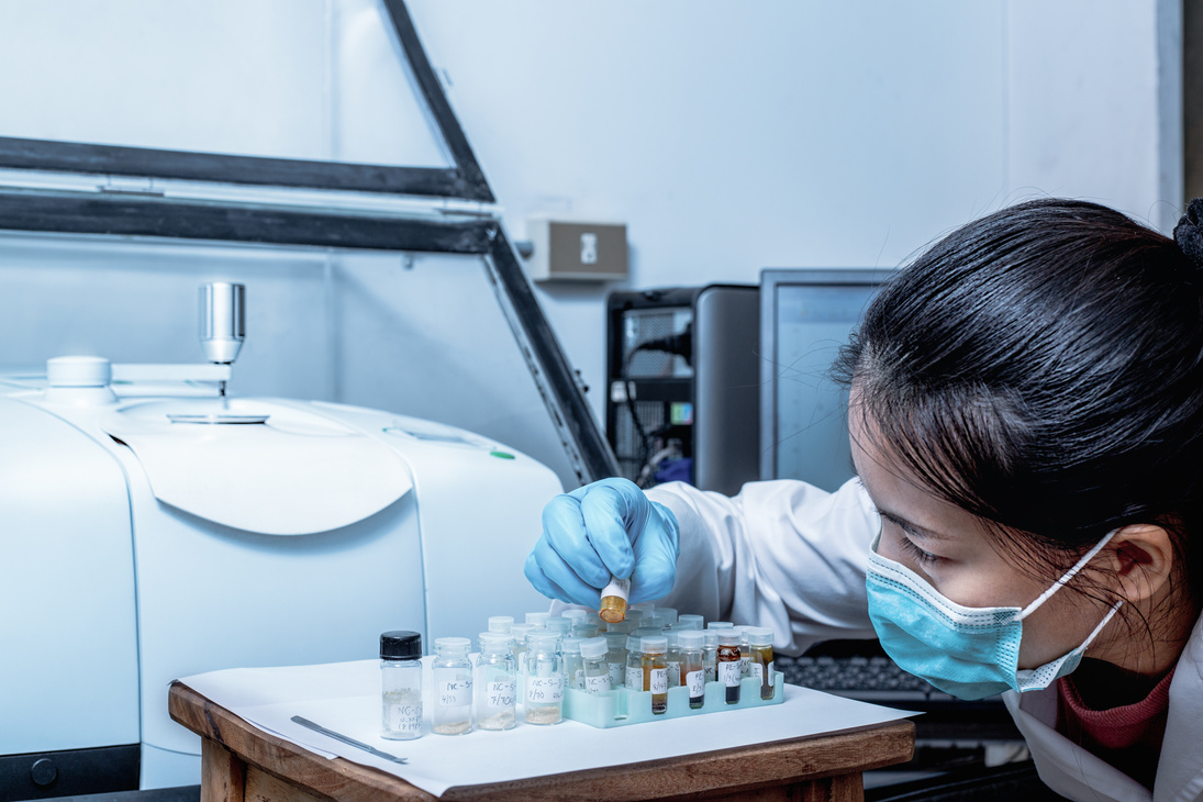 Scientist Women Check Sample in Vials for Analysis by Fourier Transform Infrared Spectroscopy FTIR Instrument.